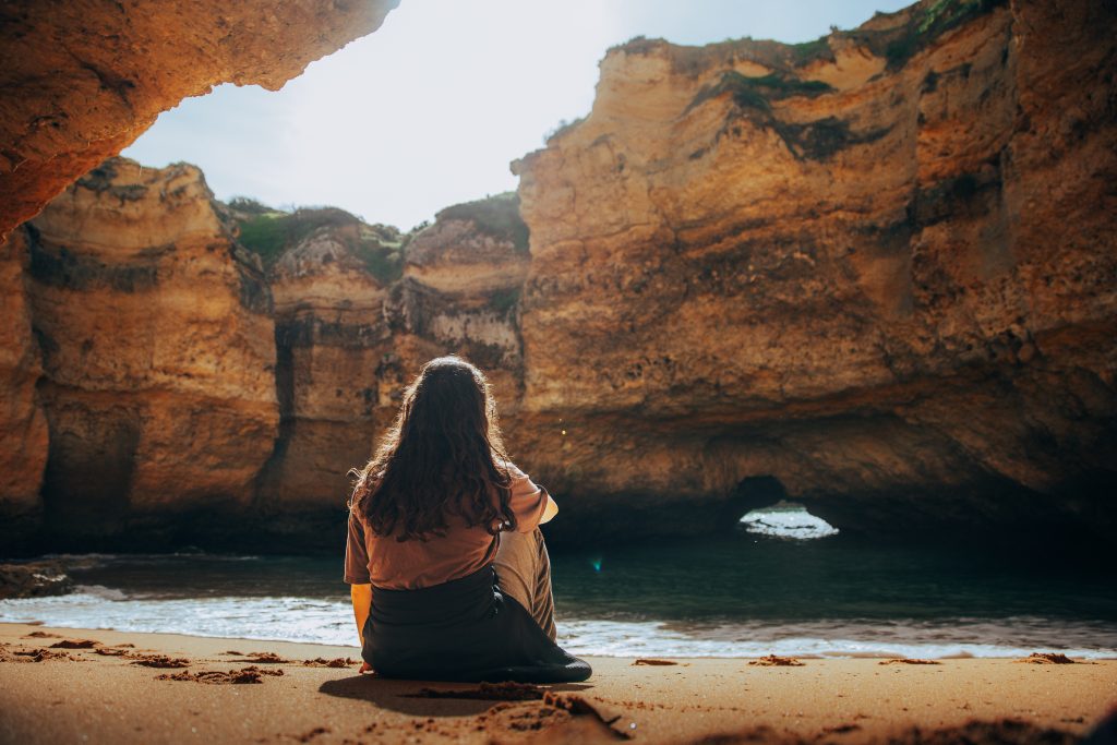 Sujet posant devant une plage de l'Algarve, au Portugal