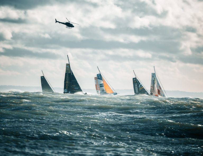 La flotte de la Route du Rhum 2022 au départ, survolée par un hélicoptère