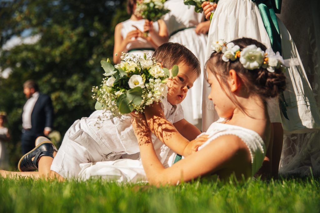 Deux enfants allongés dans l'herbe lors d'un mariage