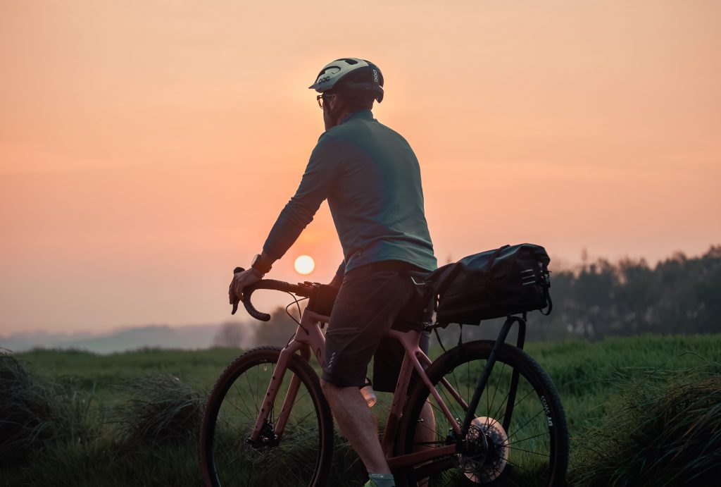 Cycliste gravel devant un coucher de soleil