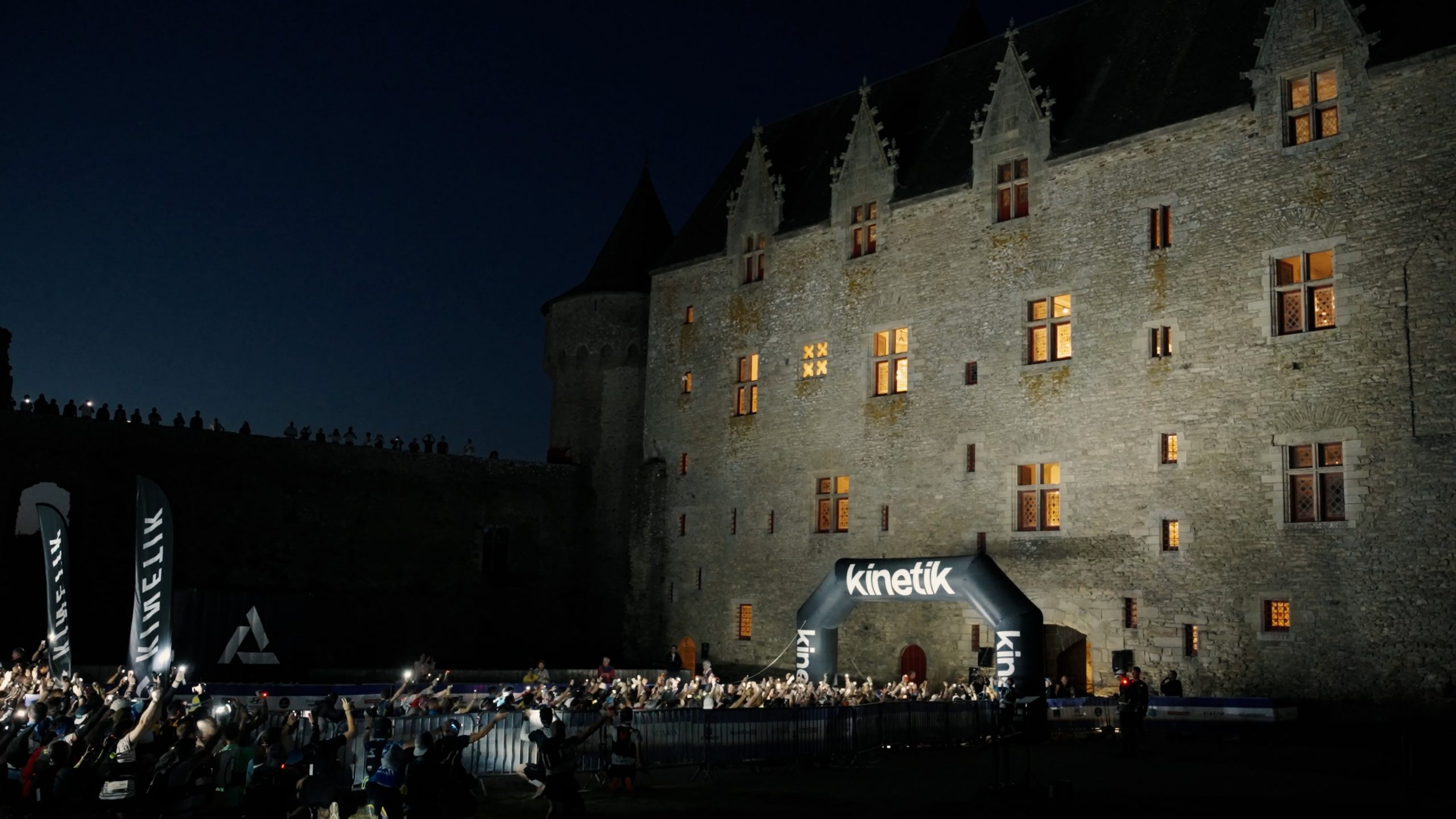 Coureurs de nuit devant un château sur le parcours du Réveil des Ducs