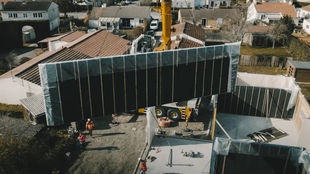 Suivi de chantier par drone : une grue pose un module de construction