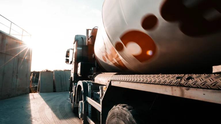 Film institutionnel : camion-citerne dans une cour industrielle, &agrave; contre-jour au soleil couchant