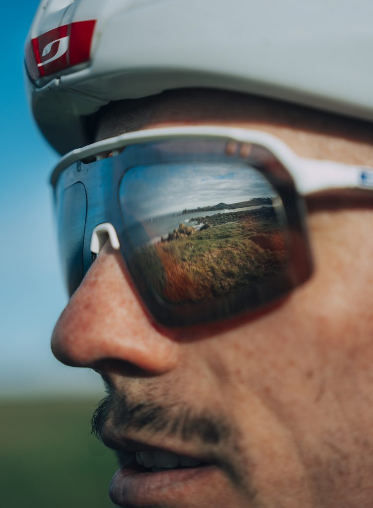 David Gaudu regardant l'horizon, la côte bretonne reflétée dans ses lunettes Julbo